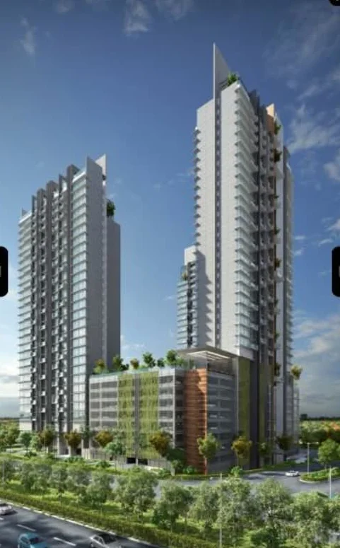Grand Medini's towers in daylight, seen from the roadside with landscaped grounds